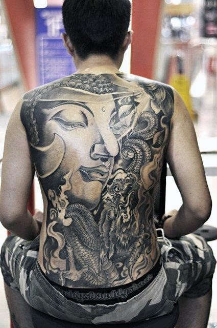 Large black ink whole back tattoo of Buddha statue with dragon