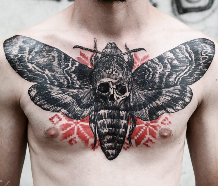 Large engraving style very detailed butterfly tattoo on chest with human skull
