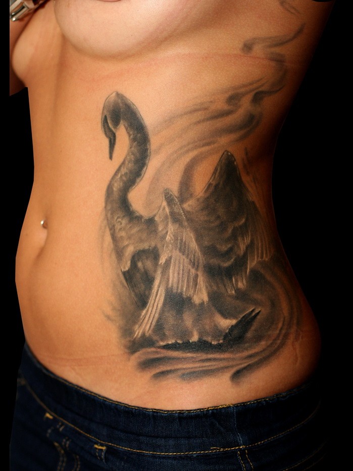 Large gray-ink swan on lake tattoo on side