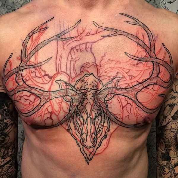 Large illustrative style colored chest tattoo of deer skull with heart