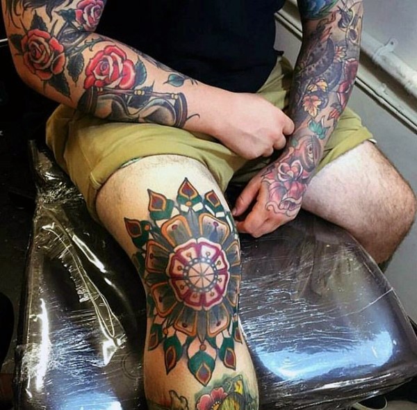 Großes mehrfarbiges Knie Tattoo mit der schönen Blume