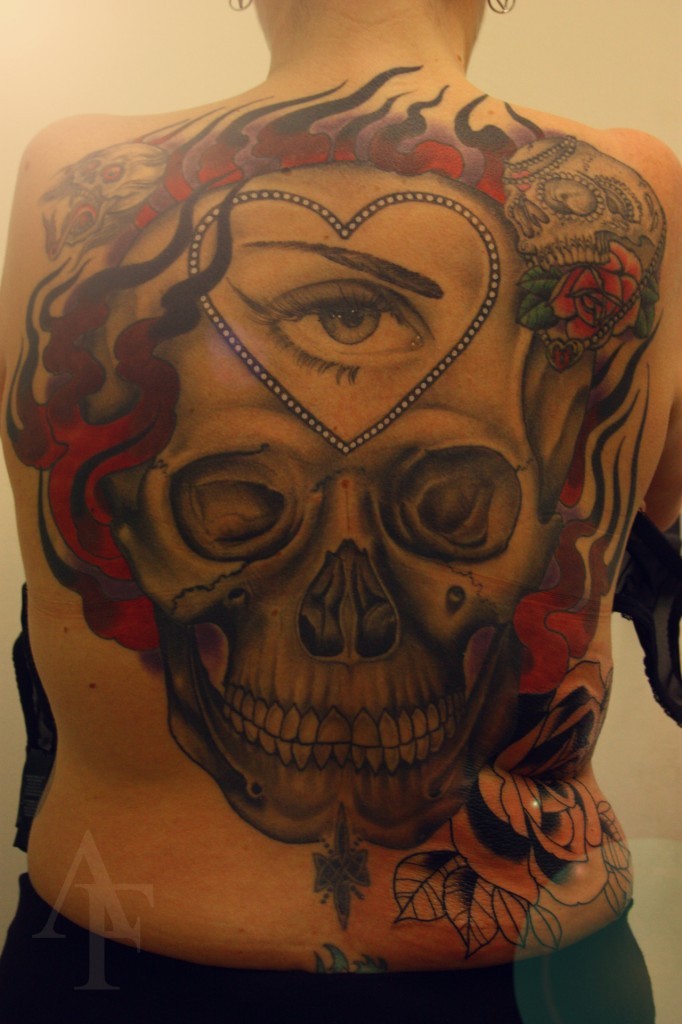 Large whole back tattoo of human skull with eye and flames