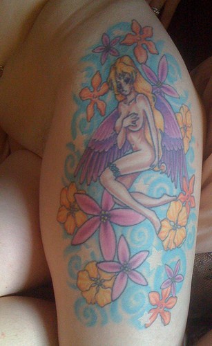 Tatuaje en la pierna, chica desnuda con alas, entre flores
