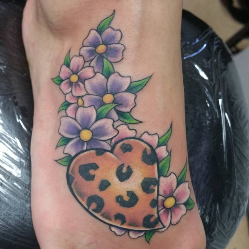 Süßes Tattoo vom Herzen mit leopardischem Muster und Blumen auf dem Fuß
