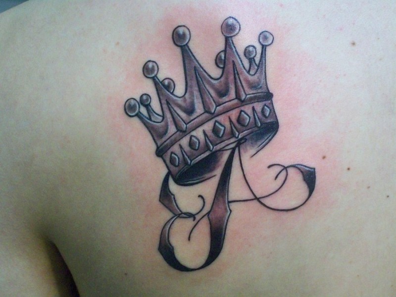 lettera e corona tatuaggio sulla scapola
