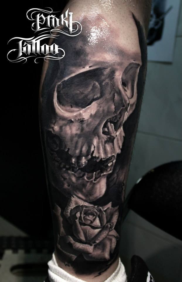 Lifelike breathtaking tattoo of big human skull and rose