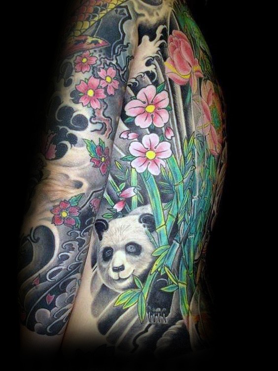 Lifelike colored tattoo of panda bear with flowers and bamboo