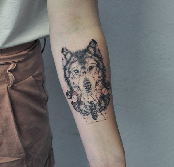 Tatuagem detalhada do antebraço realista de lobo com borboleta grande