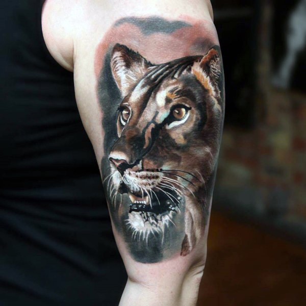 Lifelike naturally colored lioness portrait shoulder tattoo in realism style