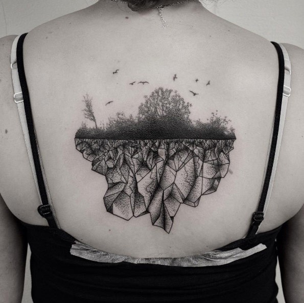Lifelike nice looking back tattoo of forest with birds and rock