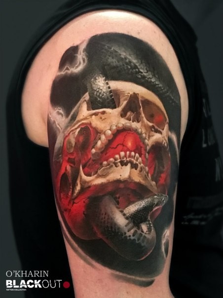 Lifelike realism style shoulder tattoo of human skull with snake