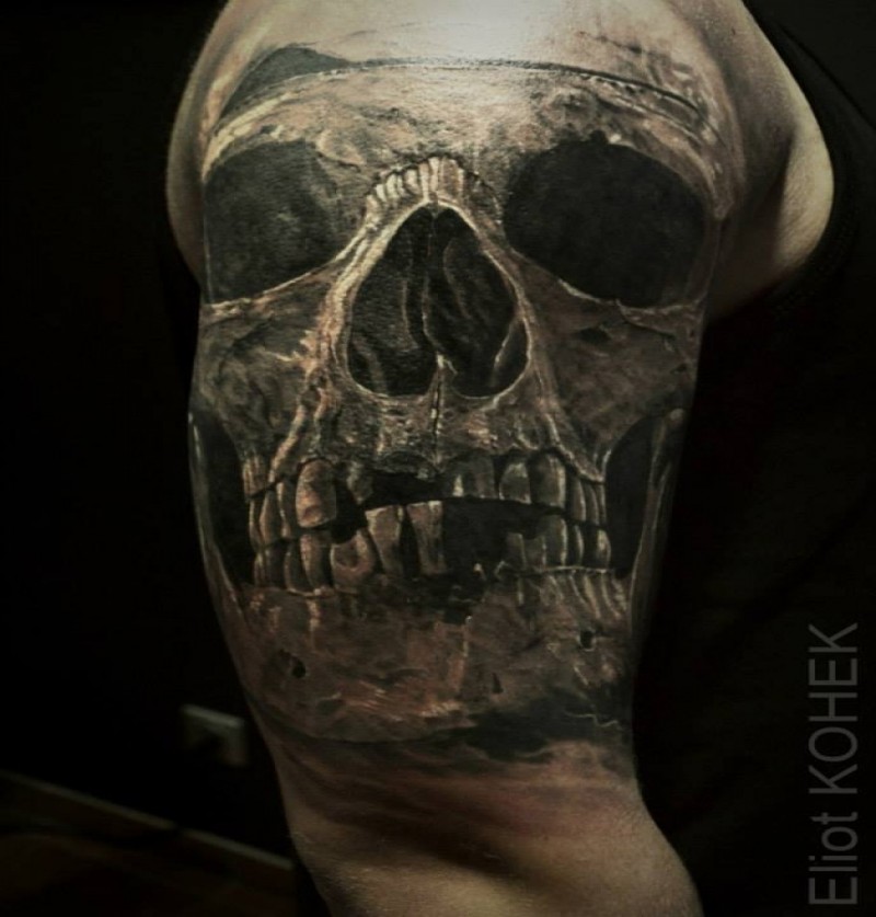 Lifelike very detailed upper arm tattoo of old human skull
