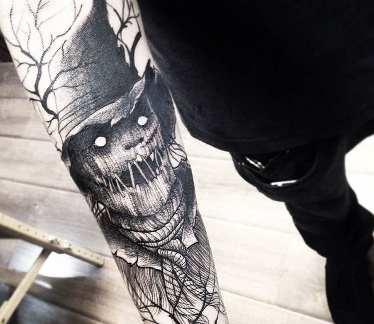 Linework style black ink forearm tattoo of evil scarecrow