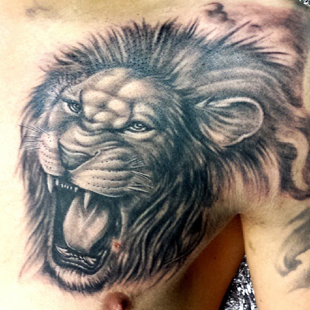 Tattoo von schön gestaltetem Löwenkopf auf der Schulter