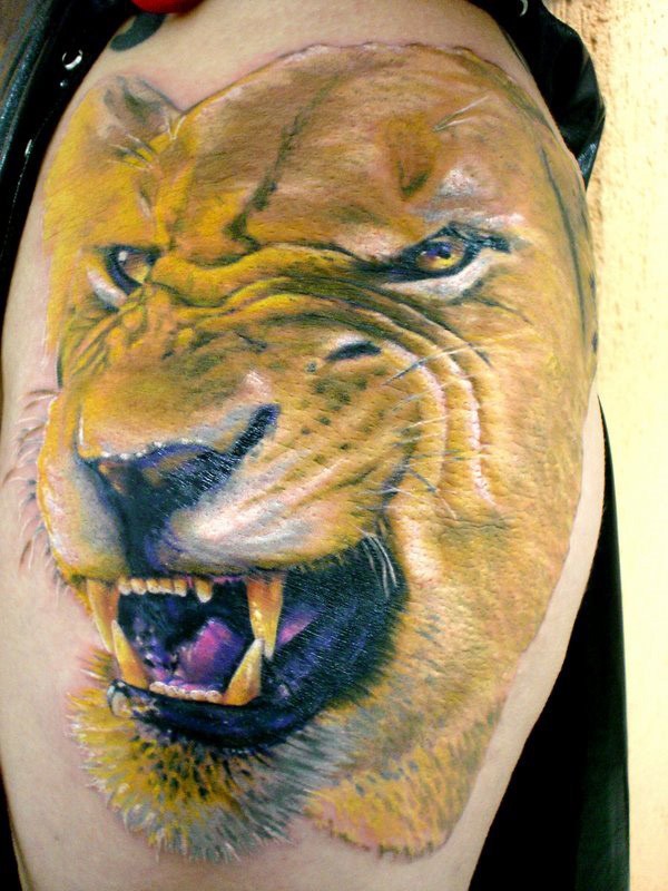 Tatuaje en el brazo, leona con dientes afilados
