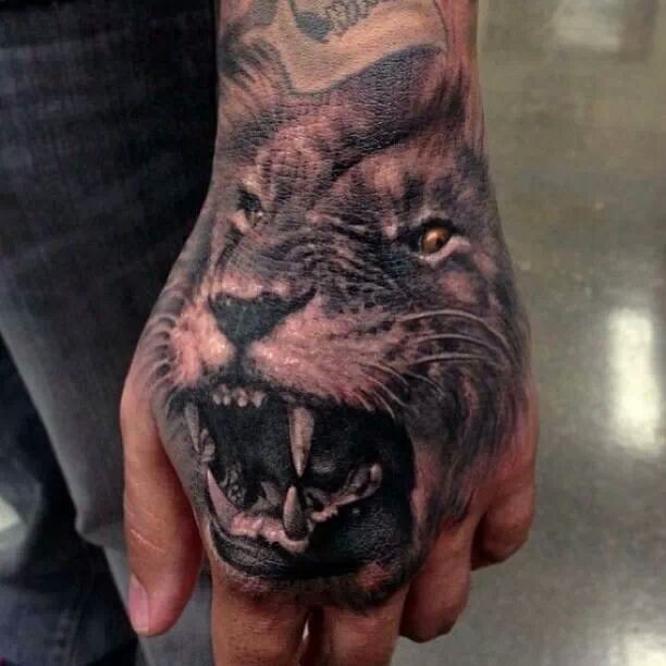 Black roaring lion tattoo on hand