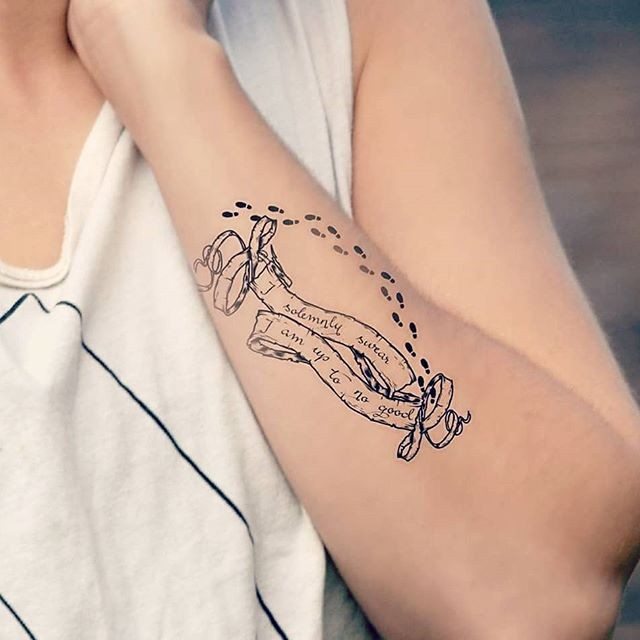 Tatuaje en el antebrazo, cinta con inscripción y huellas diminutas, tema de Harry Potter