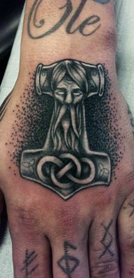 Tatuaje en la mano, ancla con rostro de deidad mitológica
