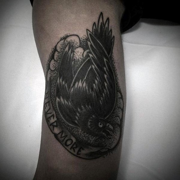 Little black and white black crow with lettering tattoo on arm