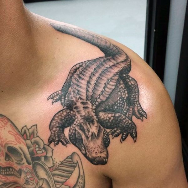 Little black and white realistic looking alligator tattoo on shoulder