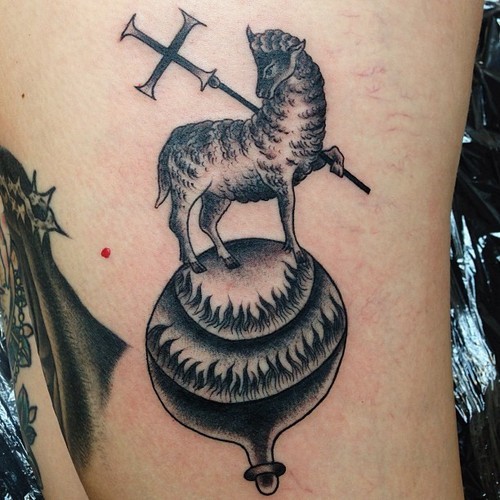 Little black and white sheep with cross tattoo