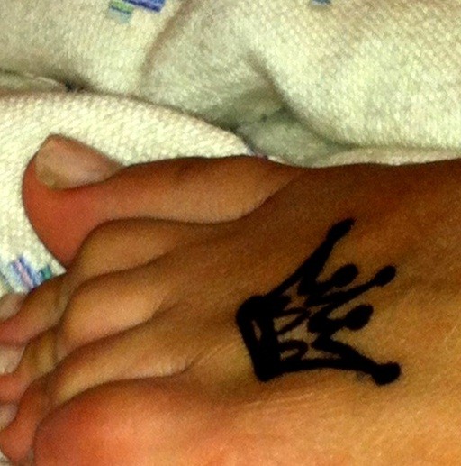 Little black crown tattoo on foot