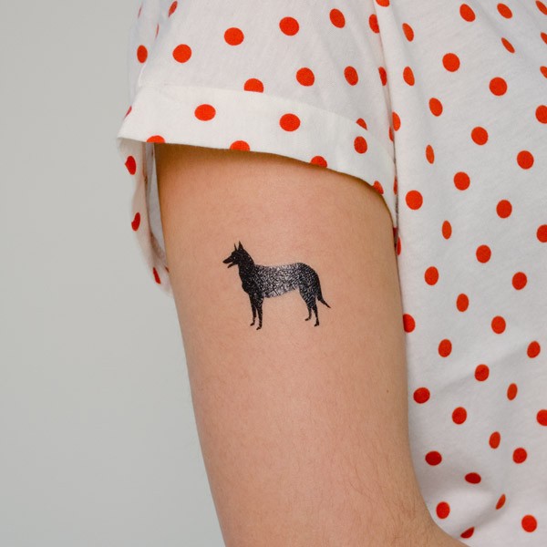 Tatuaje en el brazo,
silueta negra de pastor alemán