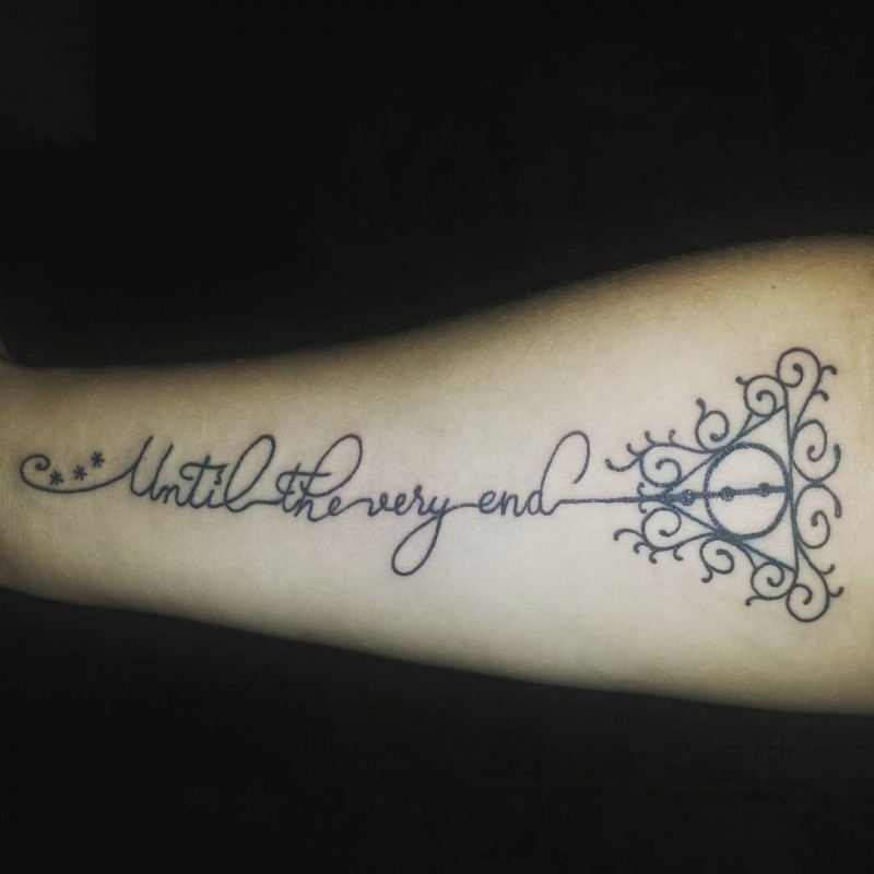 Little black ink beautiful lettering tattoo on forearm stylized with geometrical figure