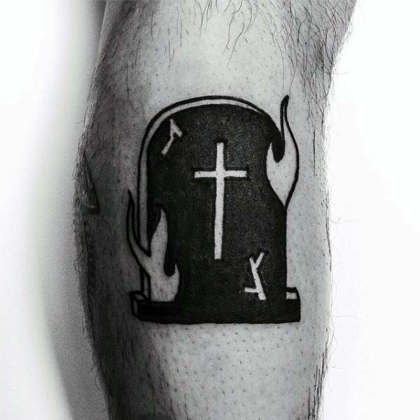 Tatuaje en la pierna, lápida mortuoria negra con cruz