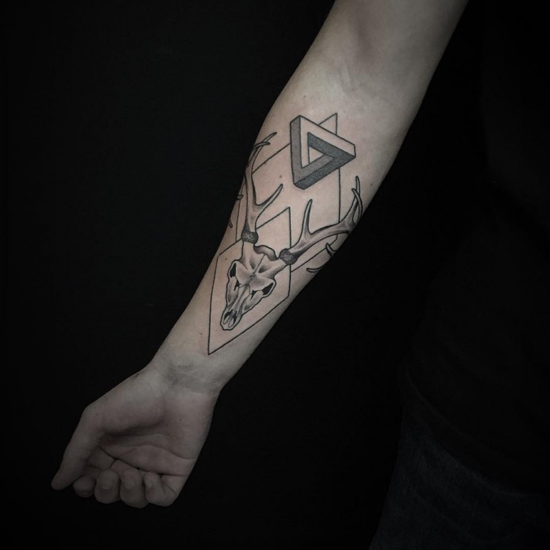Tatuaje en el antebrazo, cráneo de ciervo con figuras geométricas, colores negro blanco