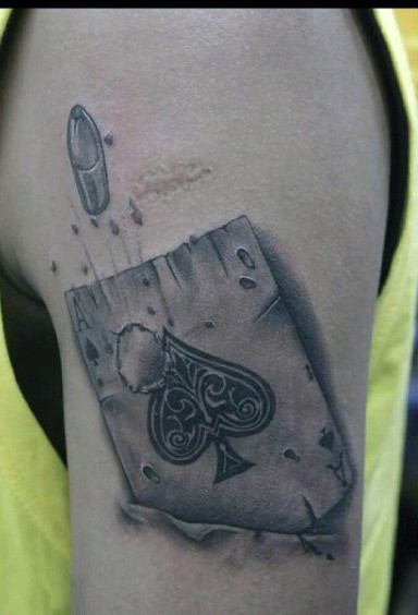 Little black ink detailed ace of spades with bullet hole tattoo on upper arm