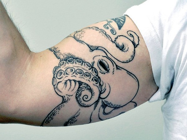 Little black ink detailed octopus tattoo on biceps