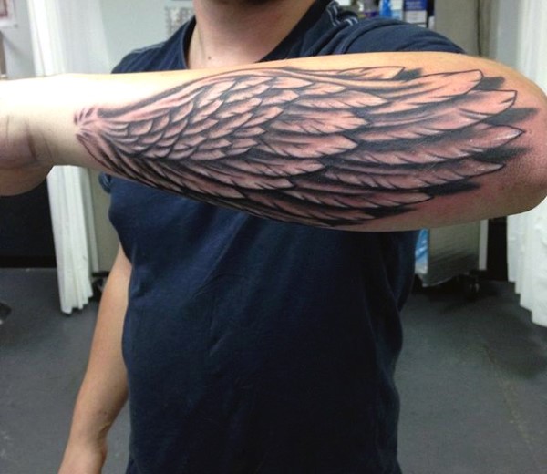 Little black ink detailed wing tattoo on arm