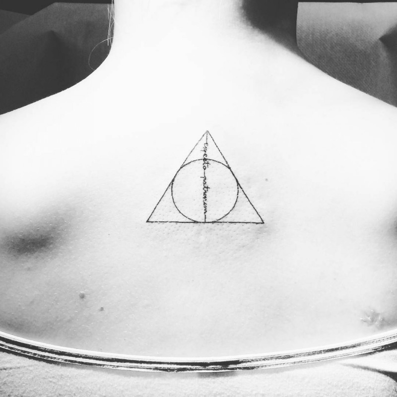 Little black ink geometrical tattoo on back with lettering