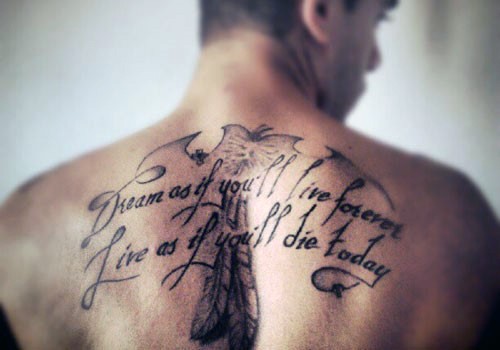 Little black ink lettering with feather tattoo on upper back