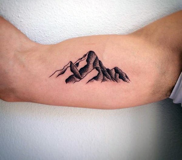 Little black ink mountains tattoo on biceps