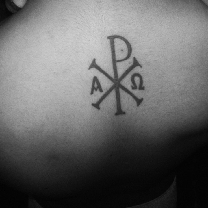 Little black ink mystical Christ monogram on back tattoo