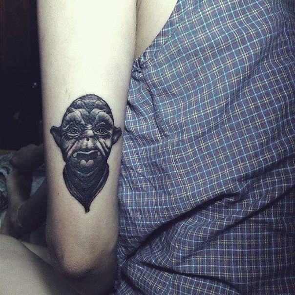 Tatuaje en el brazo,
retrato pequeño negro blanco de maestro  Yoda