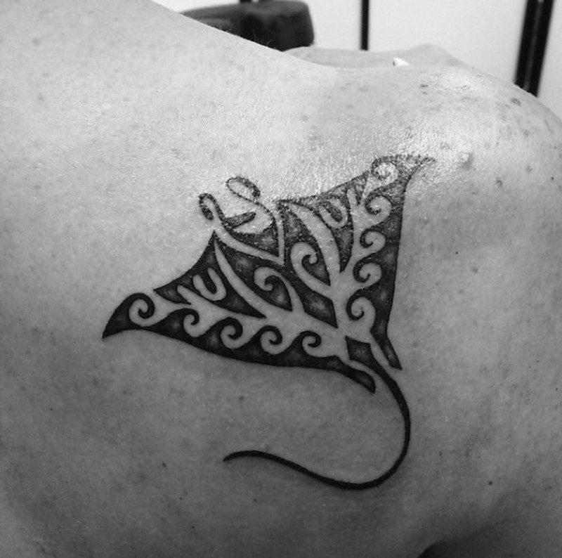 Little black ink ray tattoo on back stylized with usual ornaments