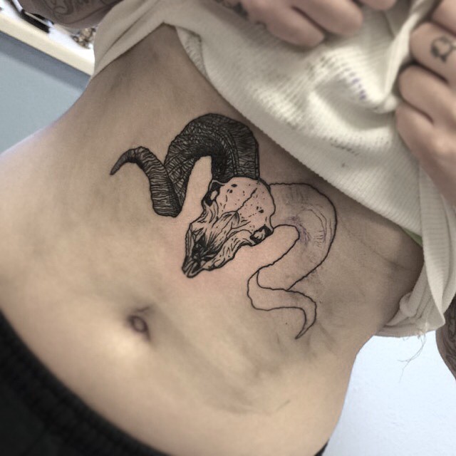 Kleiner schwarzer unvollendeter Ziegenkopf Tattoo auf der Brust