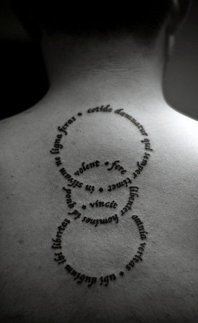 Little circle shaped lettering tattoo on upper back