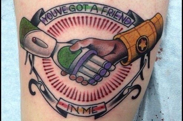 Little colored cartoon heroes hand shake tattoo with lettering