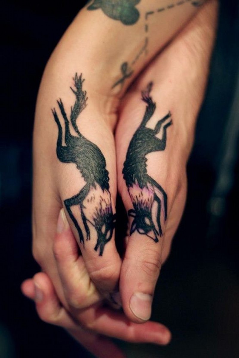 Little colored identical dogs couple tattoo on hands
