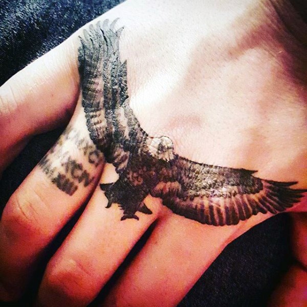 Tatuaje en la mano,  águila estupenda con alas desplegadas