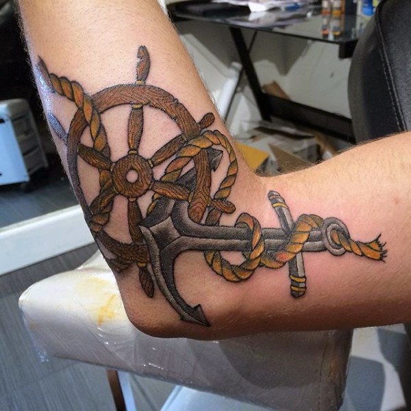 Kleiner farbiger Anker mit Lenkrad und Seil Tattoo am Arm
