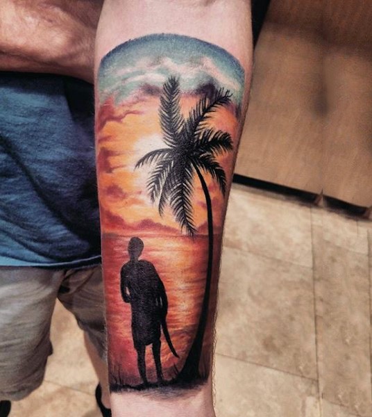 Little colorful ocean shore with surfer and palm tree tattoo on arm