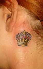 piccola corona colorata a dietro orecchio di ragazza tatuaggio