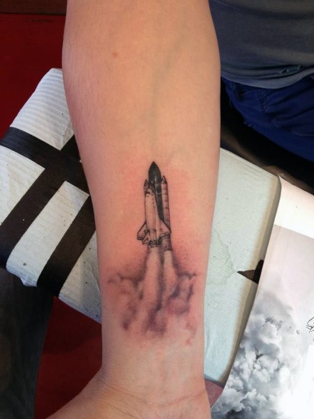 Little detailed flying space shuttle tattoo on wrist
