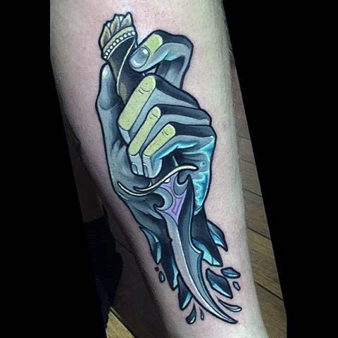 Little fantasy style colored forearm tattoo of hand with knife