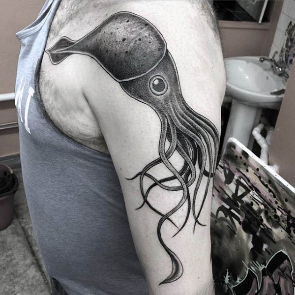 Little funny cartoon like black ink squid tattoo on shoulder zone